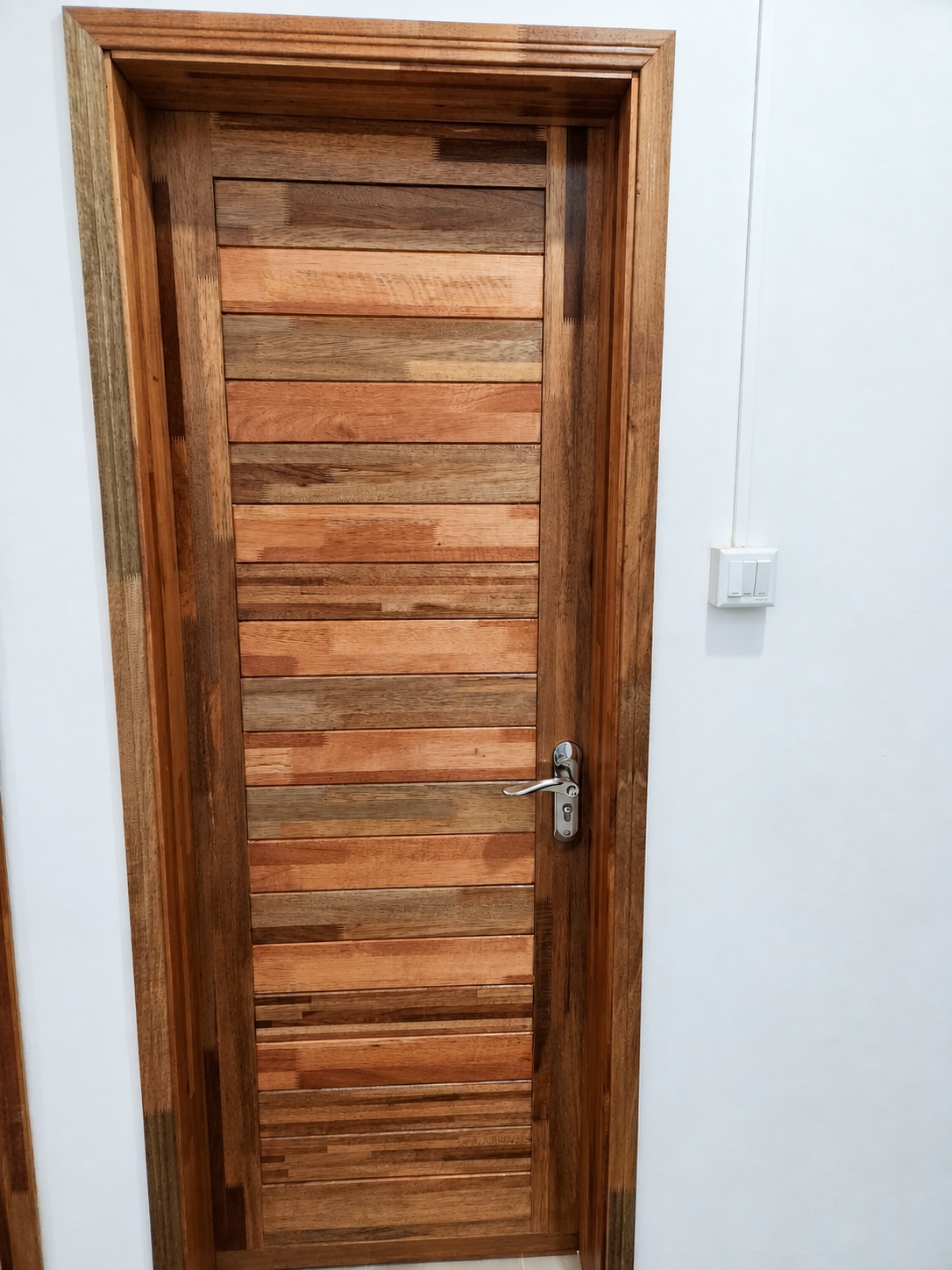 Porte en bois posée, avec panneaux horizontaux et poignée argentée